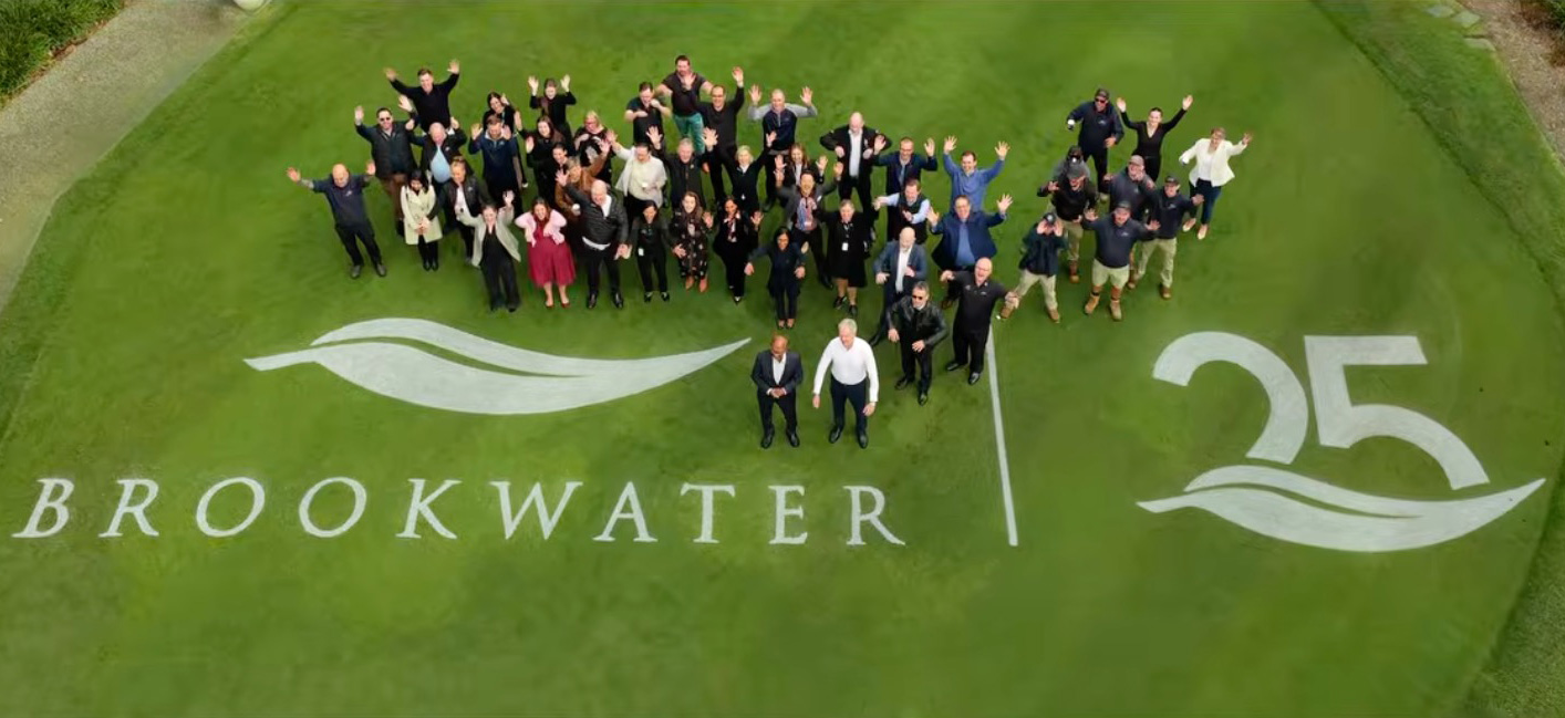 Aerial view of the Brookwater community celebrating its 25-year anniversary on the golf course, with a large group gathered around the Brookwater 25-year logo